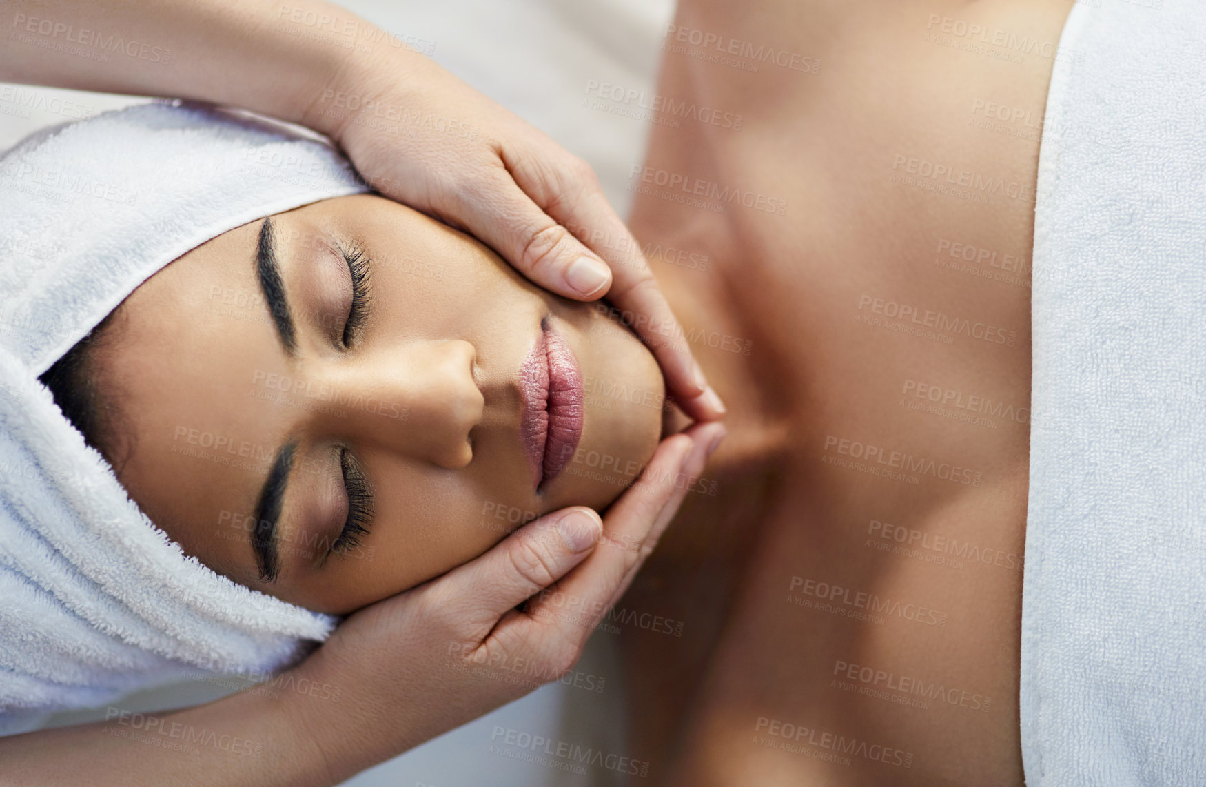Buy stock photo Woman, hands and face in relax for massage, skincare or beauty spa treatment on bed above at resort. Top view of female relaxing with eyes closed for calm therapy, healthy wellness or cosmetic facial
