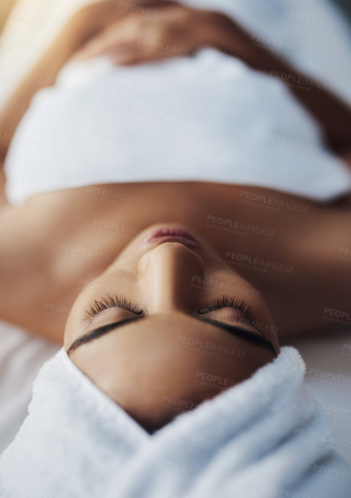 Buy stock photo Shot of a young woman relaxing on a massage table at a spa