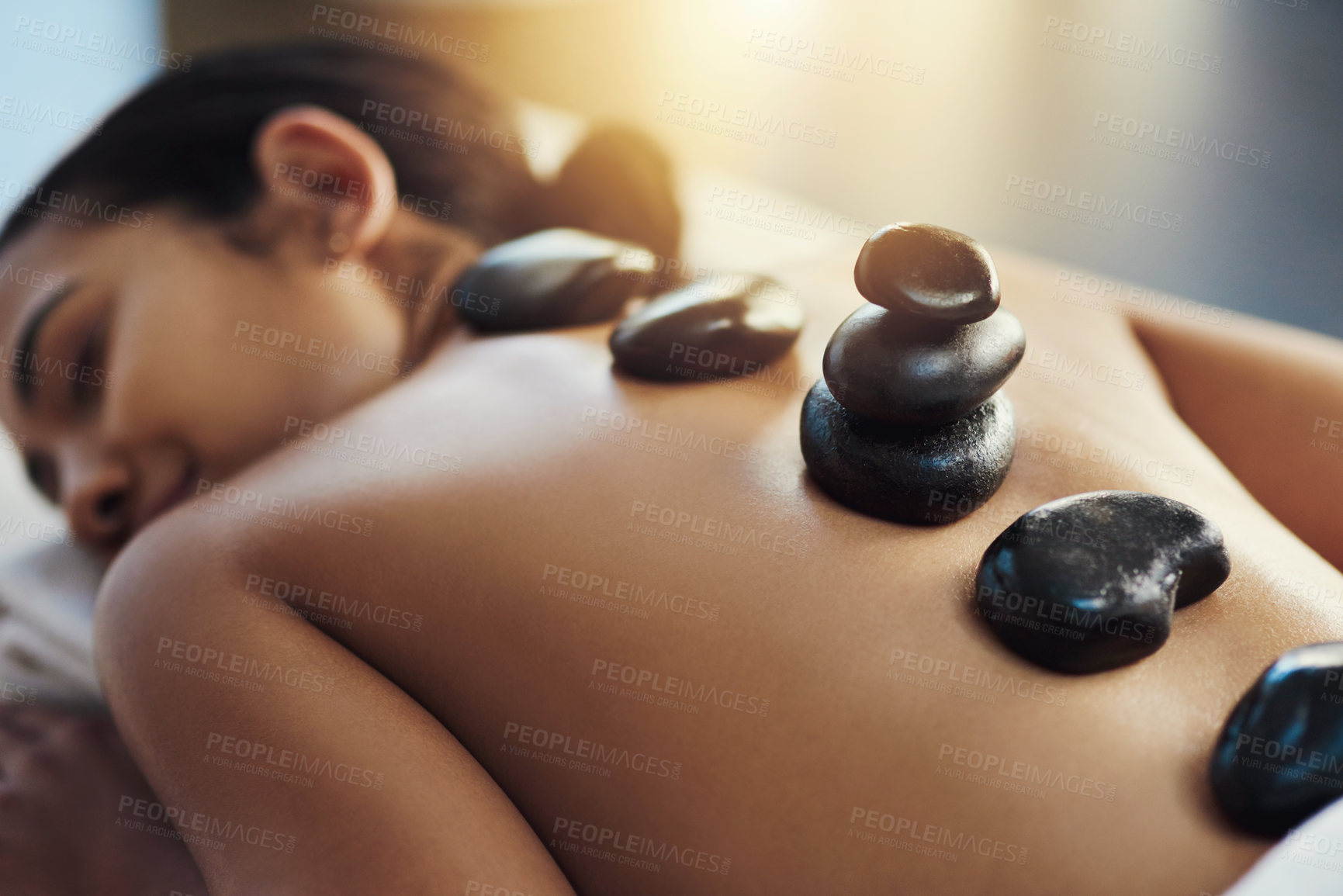 Buy stock photo Happy woman, sleeping and hot rock massage at spa for skincare, beauty or body treatment at resort. Calm female asleep with heated rocks on back for healthy physical therapy, zen or wellness at salon