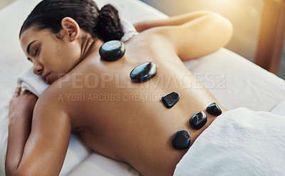 Buy stock photo Woman, sleeping and stone massage at spa for skincare, beauty or body treatment on bed at resort. Calm female lying in relaxation with hot rocks on back for physical therapy, zen or wellness at salon