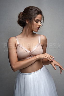 Buy stock photo Studio shot of an attractive young female ballet dancer posing against a grey background