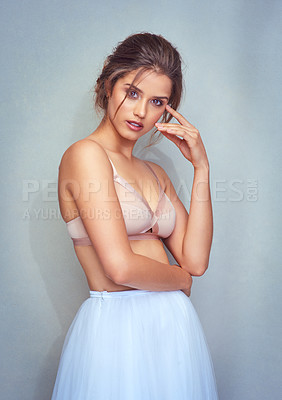 Buy stock photo Studio portrait of an attractive young female ballet dancer posing against a grey background