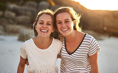 Buy stock photo Cropped shot of two friends spending the day at the beach