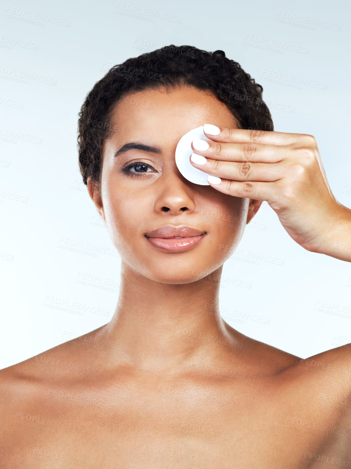 Buy stock photo Portrait of an attractive young woman posing while covering her one eye with a cotton pad against a white background