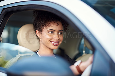 Buy stock photo Cropped shot of an attractive young businesswoman smiling while driving her new car