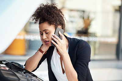 Buy stock photo Cropped shot of a frustrated young businesswoman calling roadside assistance after her car broke down