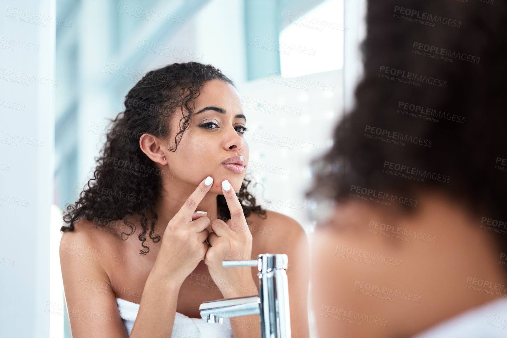 Buy stock photo Cropped shot of a beautiful young woman squeezing a pimple while looking in the mirror