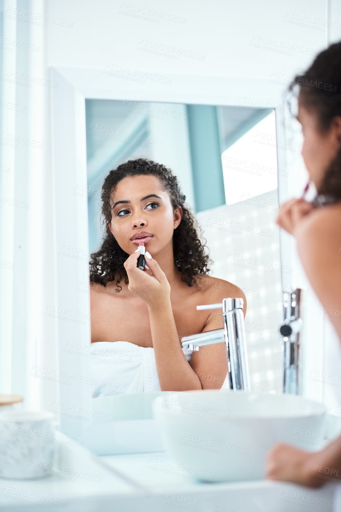Buy stock photo Shot of a beautiful woman applying lipstick in her bathroom mirror