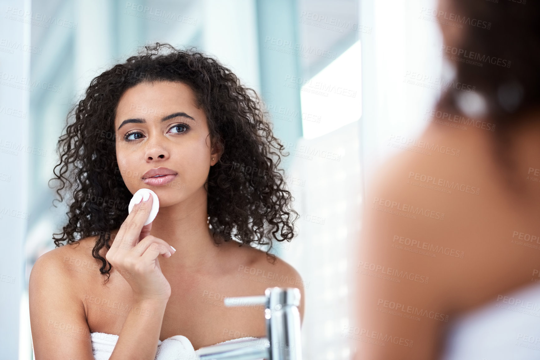 Buy stock photo Shot of a beautiful young woman cleaning her face with cotton wool