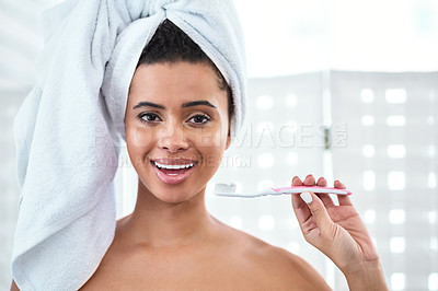 Buy stock photo Shot of a beautiful young woman brushing her teeth at home