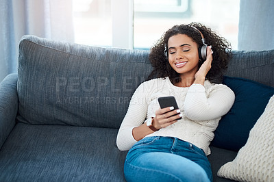 Buy stock photo Woman, smile and music with cellphone, headphones and podcast at home or apartment living room. Lady, couch and relax for internet, connectivity and audio streaming for happiness on sofa in lounge