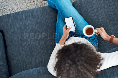 Buy stock photo Shot of a woman using her cellphone while enjoying a hot beverage