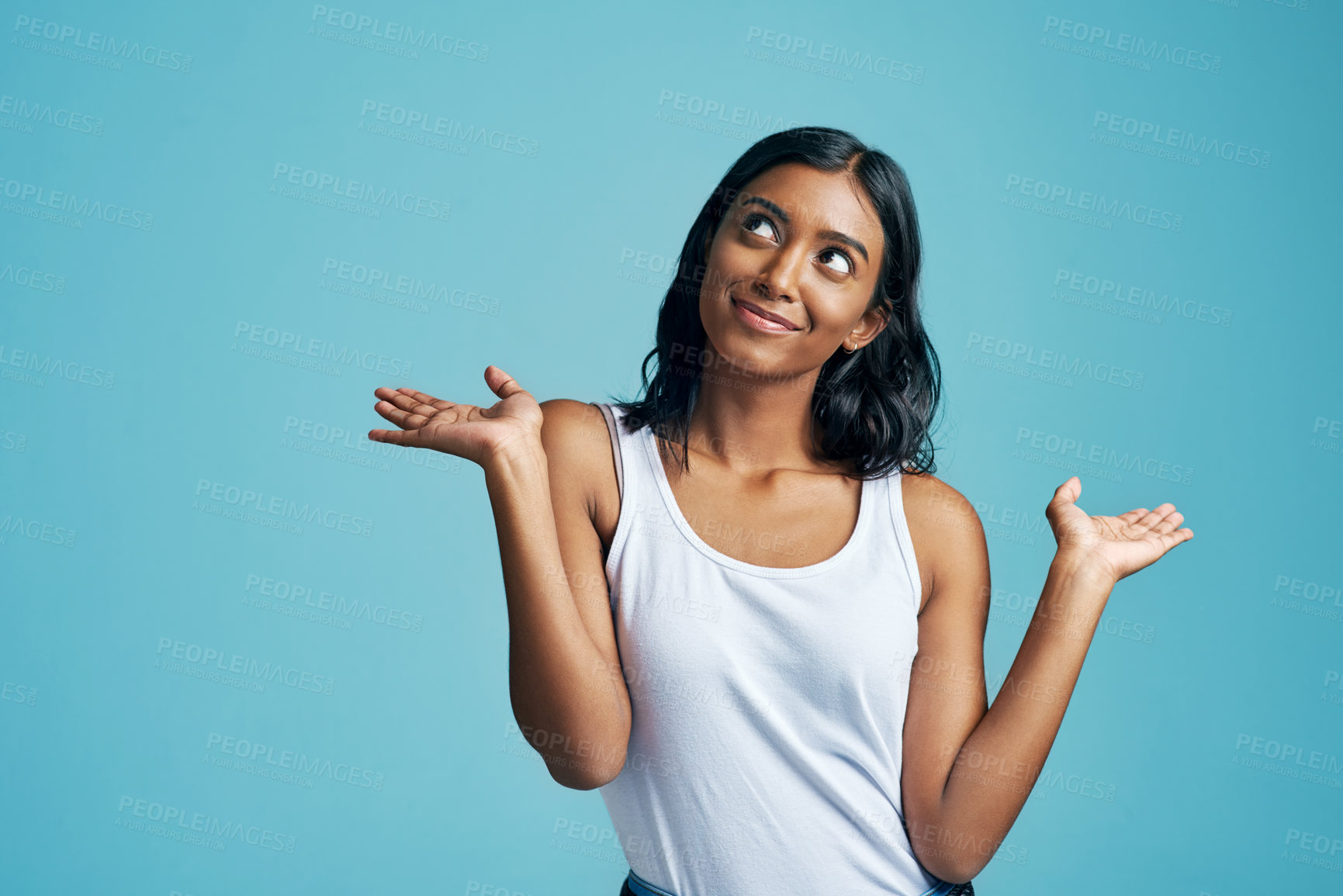 Buy stock photo Comparison, thinking and woman with a choice in a studio with a question, idea or dream. Decision, doubt and Indian female model with option or shrug hand sign by blue background with mockup.