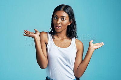 Buy stock photo Options, choice gesture and portrait of woman in studio with shock, surprise or thinking face. Decision, idea and Indian female model with comparison or shrug hand sign by blue background with mockup