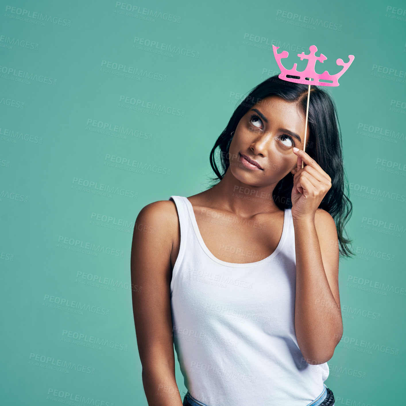 Buy stock photo Studio shot of a beautiful young woman posing with a prop crown against a green background