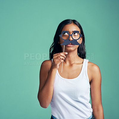 Buy stock photo Studio shot of a beautiful young woman posing with prop glasses against a green background