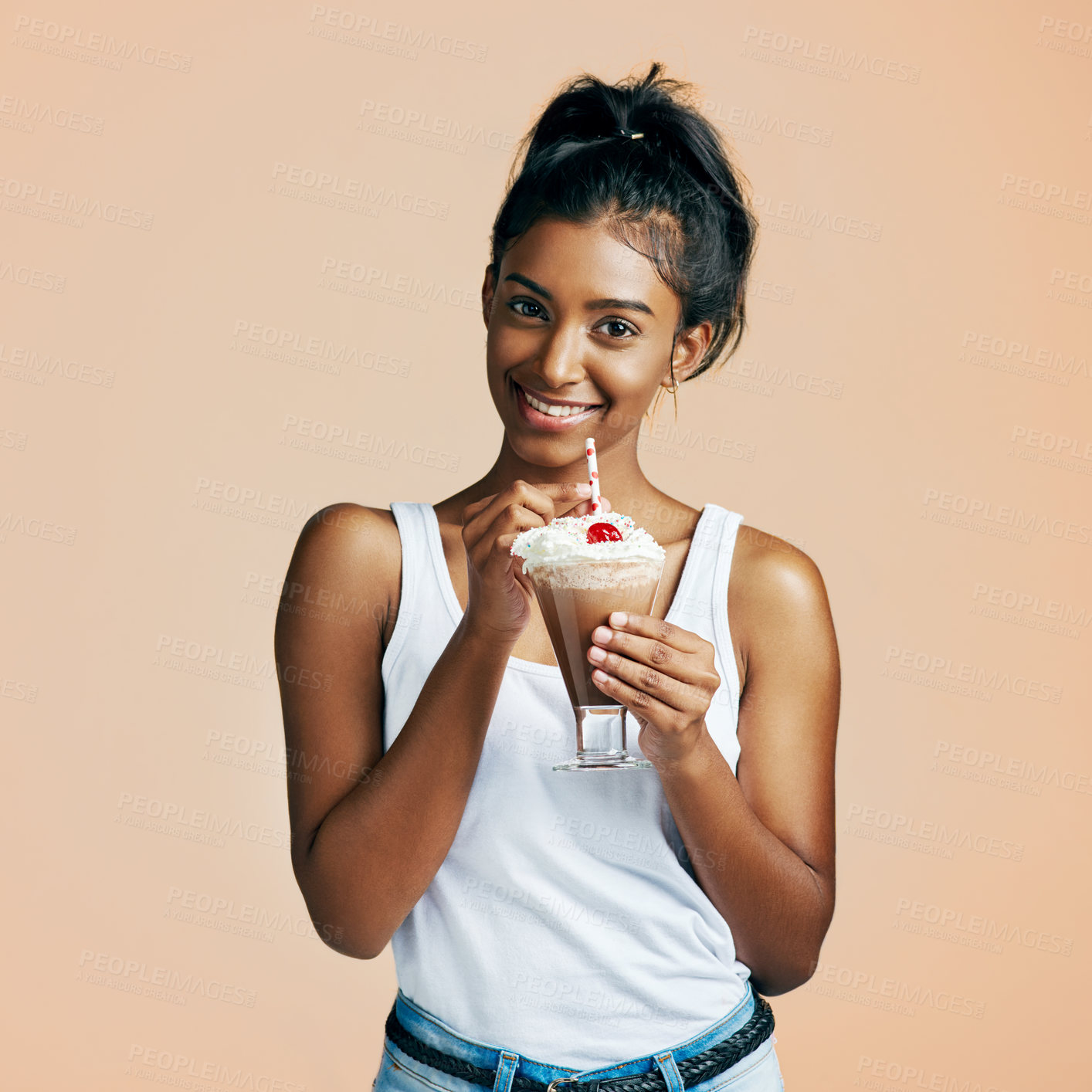 Buy stock photo Studio portrait of a beautiful young woman posing with a chocolate milkshake against an orange background