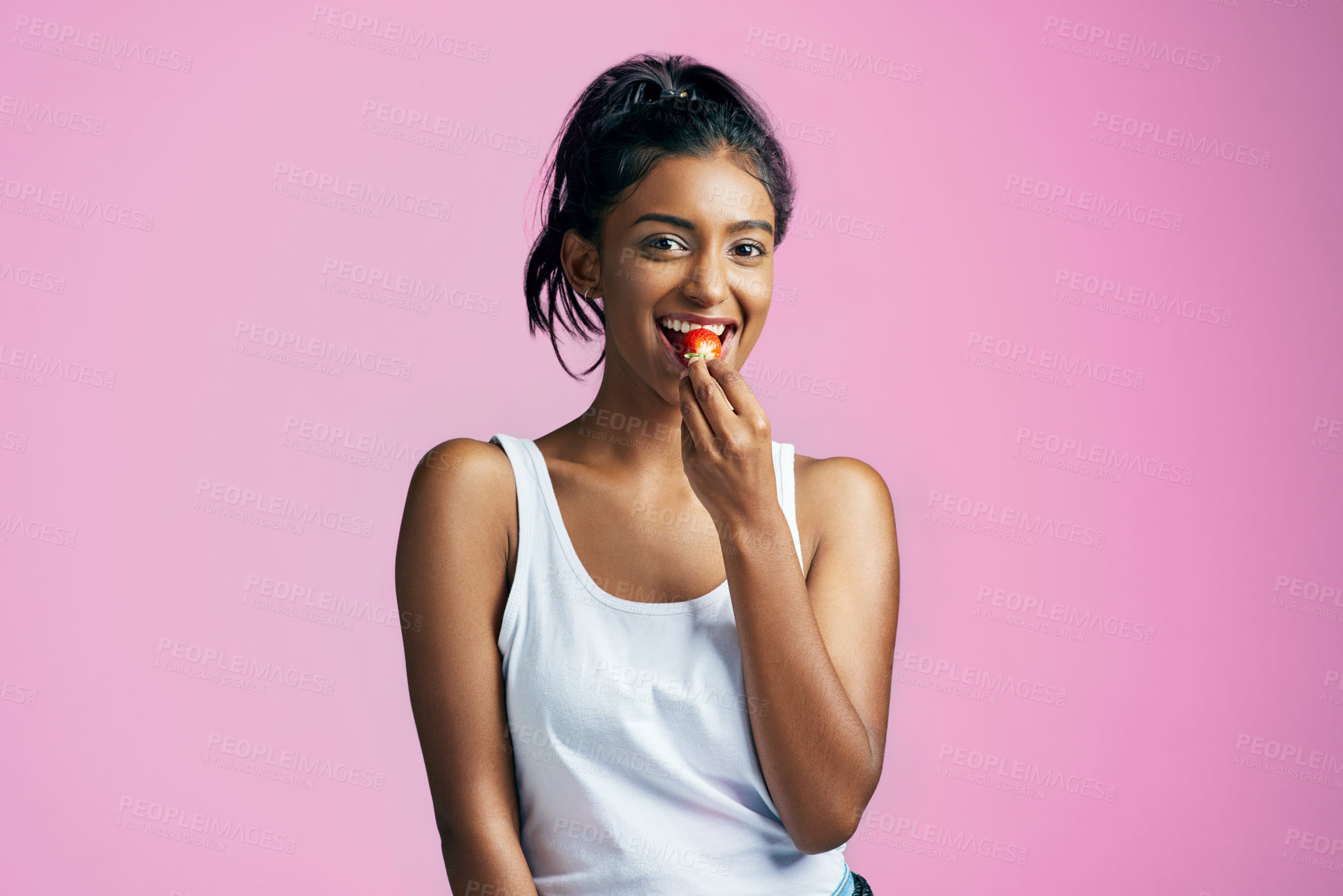 Buy stock photo Eat, portrait and girl with strawberry in studio for diet, healthy snack or wellness on pink background. Fruit, vitamin c and hand of Indian woman for detox, antioxidants or weight loss on mockup