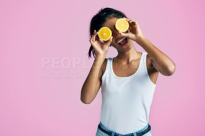 Buy stock photo Studio shot of a beautiful young woman posing with oranges over her eyes against a pink background