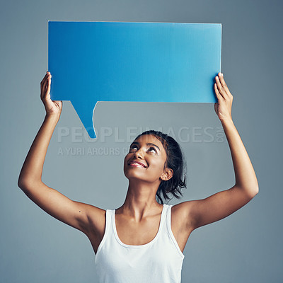 Buy stock photo Studio shot of a beautiful young woman holding up a blank signboard against a grey background