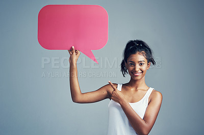 Buy stock photo Studio portrait of a beautiful young woman holding up a blank signboard against a grey background