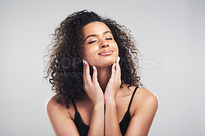 Buy stock photo Studio shot of a beautiful young woman touching her skin against a grey background