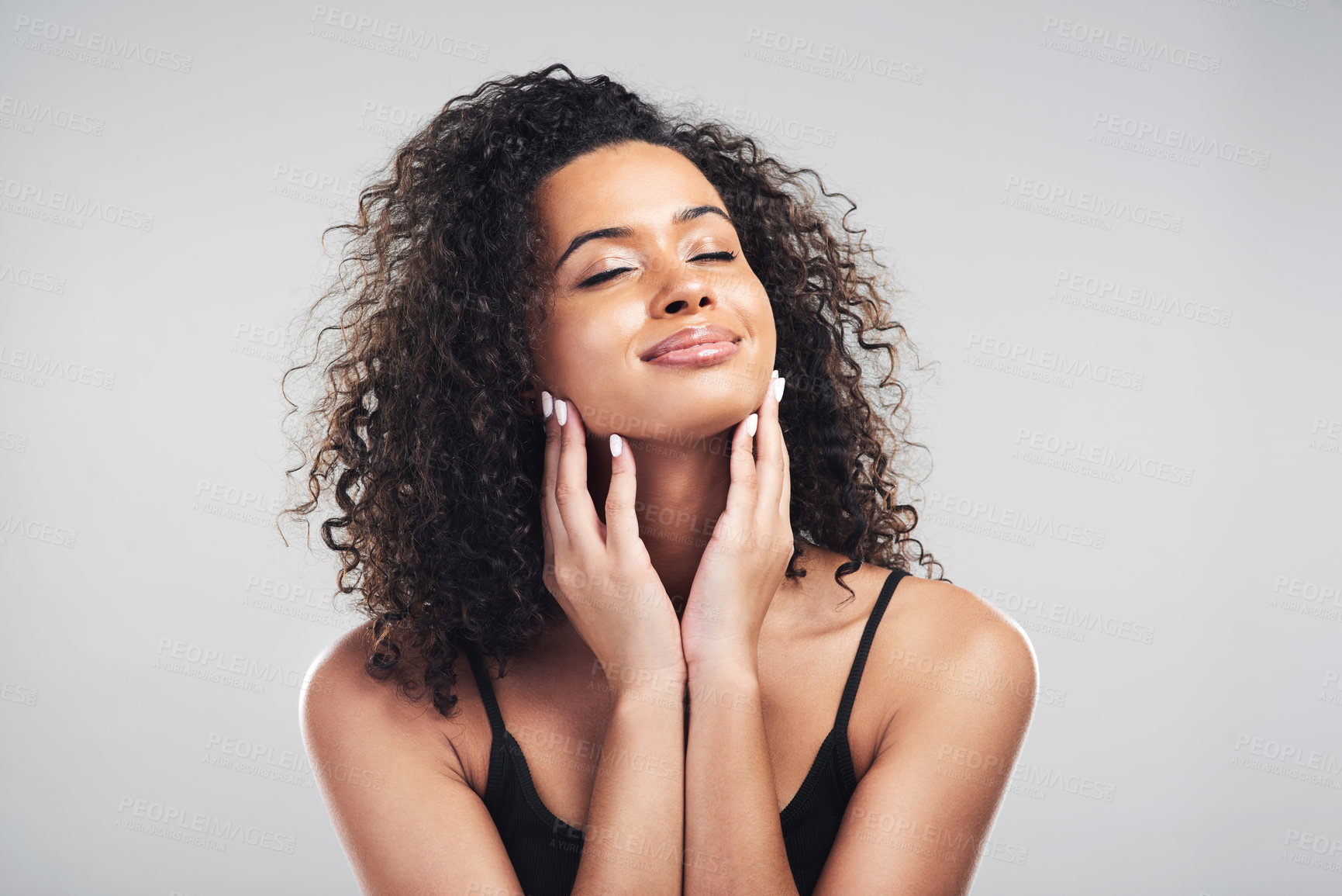 Buy stock photo Studio shot of a beautiful young woman touching her skin against a grey background