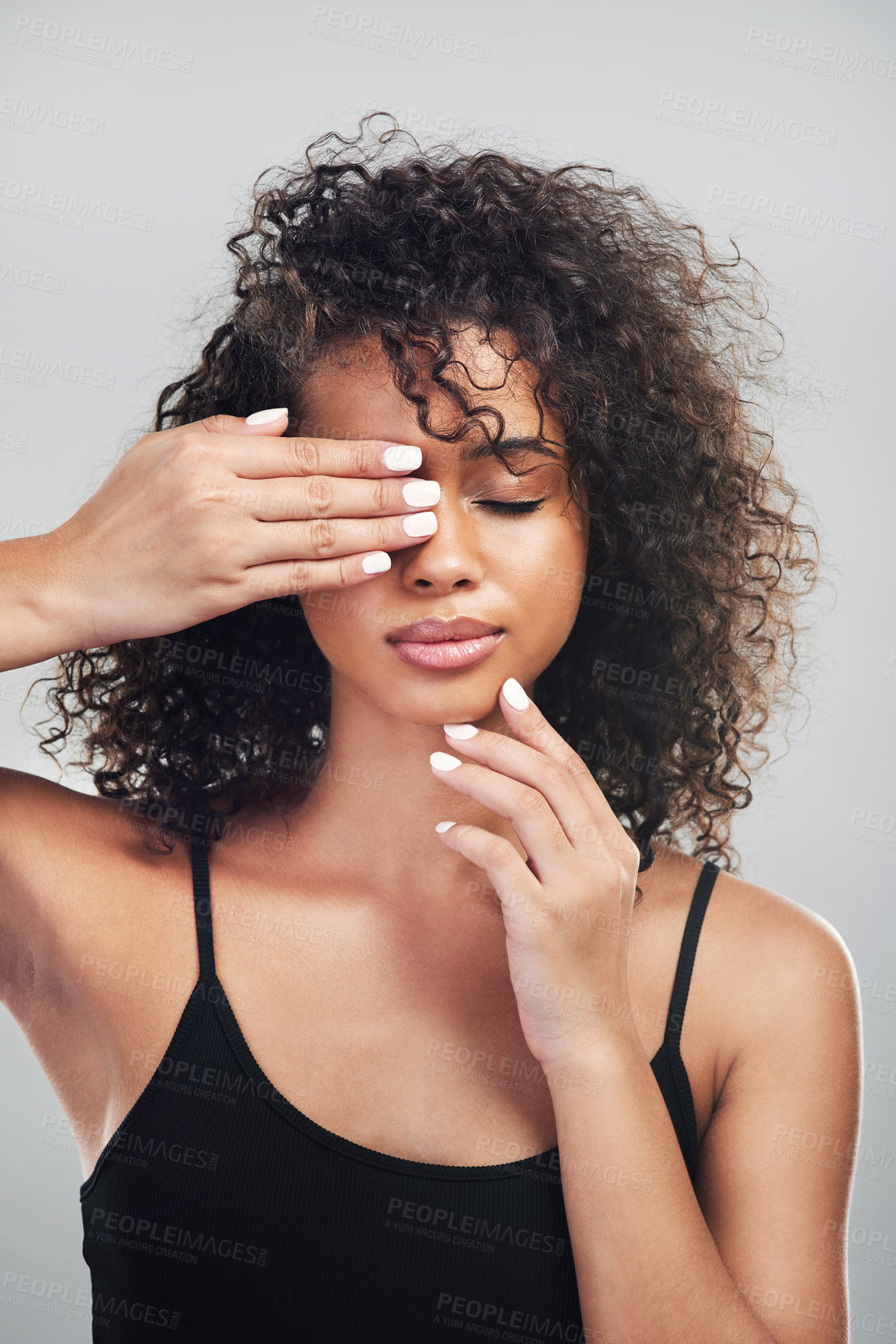 Buy stock photo Studio shot of a beautiful young woman posing with her hand over her eye