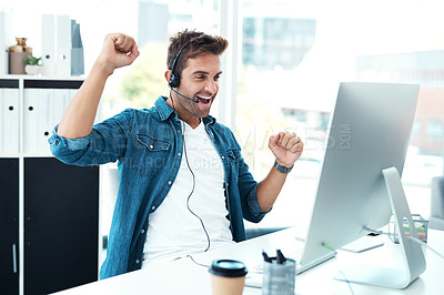 Buy stock photo Shot of a cheerful male call centre agent punching the air in celebration in his office