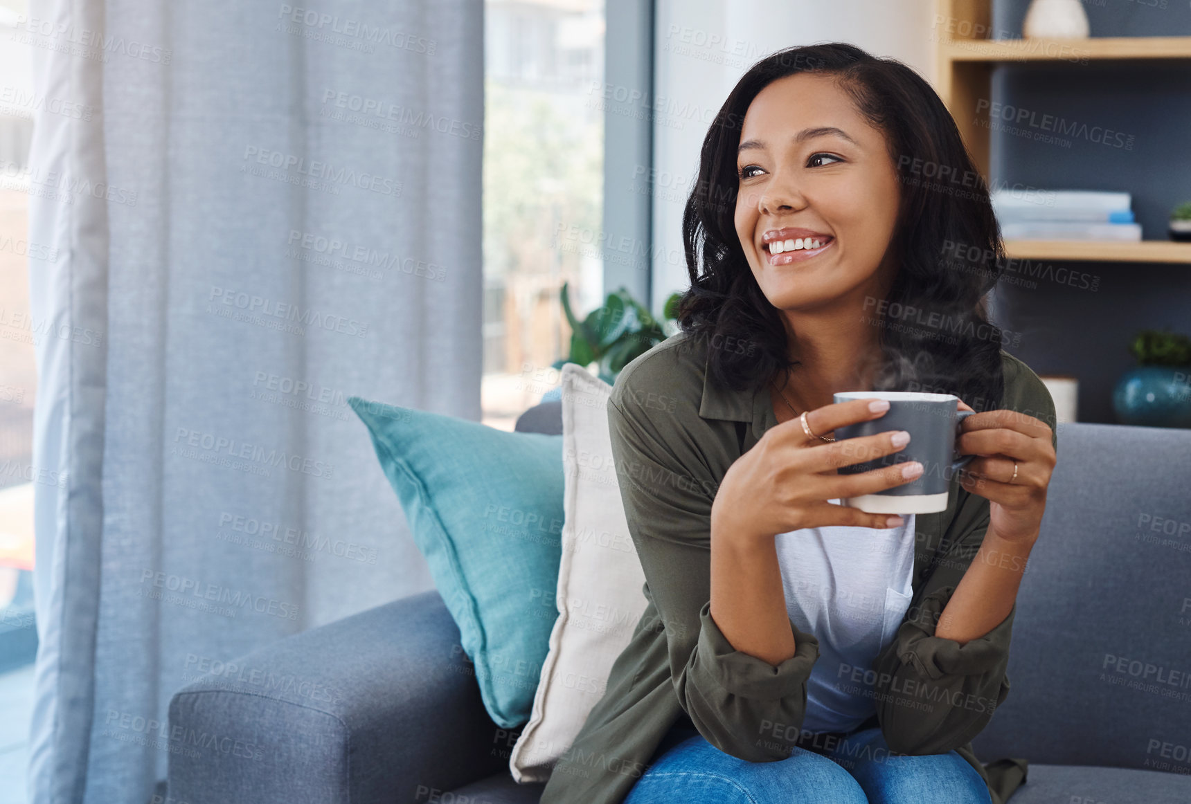 Buy stock photo Shot of an attractive young woman having coffee and relaxing on the sofa at home