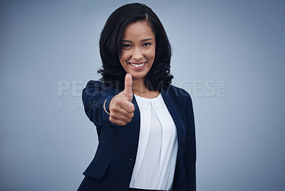 Buy stock photo Studio portrait of a young businesswoman showing thumbs up against a grey background