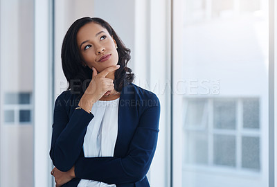 Buy stock photo Shot of a young businesswoman looking thoughtful in an office