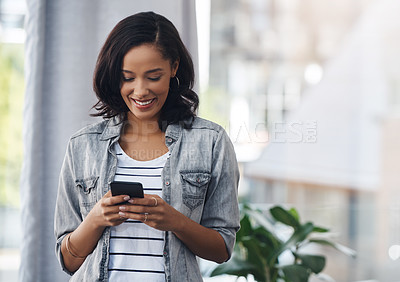 Buy stock photo Shot of a young woman using a cellphone at home