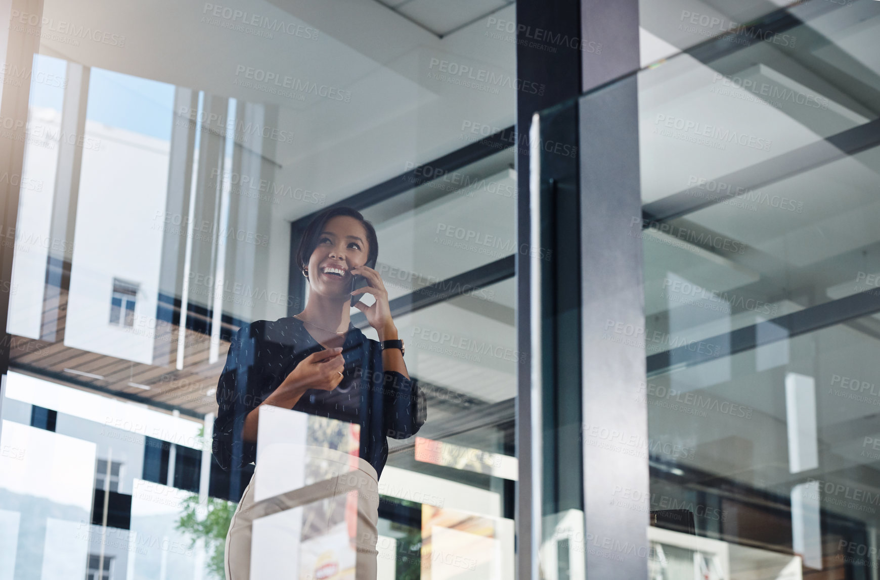 Buy stock photo Shot of a young businesswoman talking on a cellphone in an office