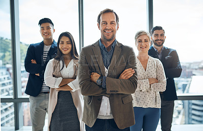Buy stock photo Portrait of a group of confident young businesspeople standing together with their arms folded inside the office during the day