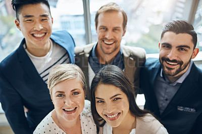 Buy stock photo Portrait of a group of confident young businesspeople standing together in the office at work during the day