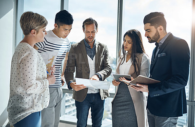Buy stock photo Cropped shot of a group of young businesspeople having a discussion together inside of the office during the day