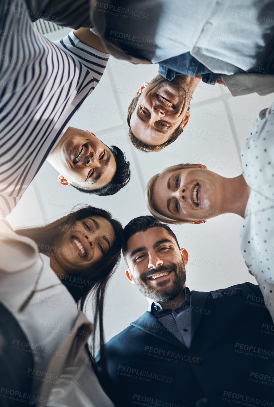 Buy stock photo Low angle portrait of a group of confident young businesspeople standing together in the office at work during the day