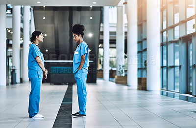 Buy stock photo Shot of two medical practitioners having a discussion in a hospital