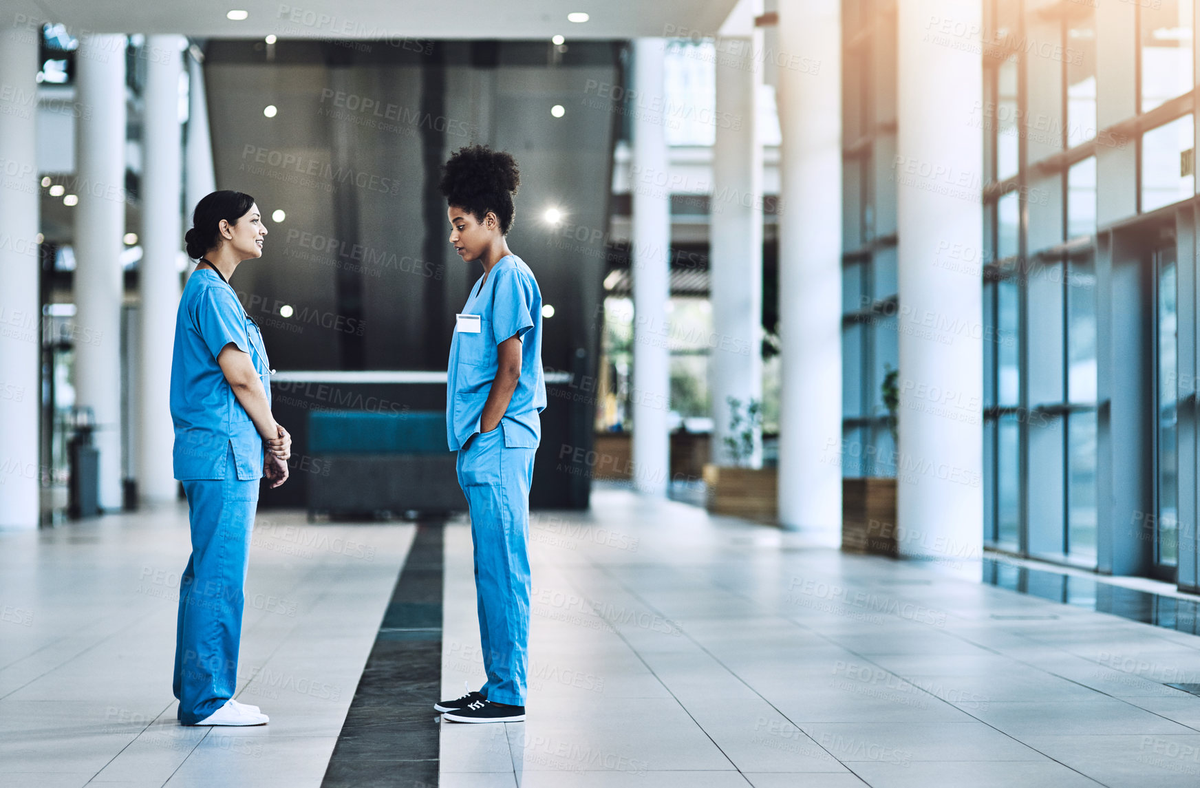 Buy stock photo Shot of two medical practitioners having a discussion in a hospital