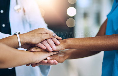 Buy stock photo Cropped shot of a team of doctors joining their hands together in unity