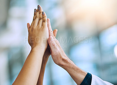 Buy stock photo Shot of a diverse team of doctors giving each other a high five in a hospital