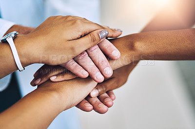 Buy stock photo Cropped shot of a team of doctors joining their hands together in unity