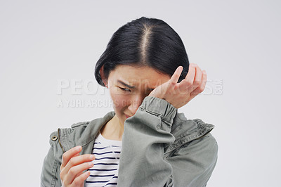 Buy stock photo Crying, stress and sad woman in studio with depression, crisis and broken heart on grey background. Pain, sorrow and emotional Asian girl frustrated by worry, anxiety and grief with loss or bad news
