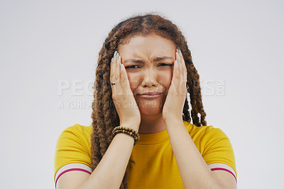 Buy stock photo Studio shot of a young woman crying while standing against a gray background