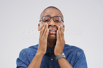 Buy stock photo Studio shot of a young man crying while standing against a gray background