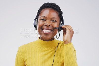 Buy stock photo Studio portrait of an attractive young female customer service representative wearing a headset against a grey background