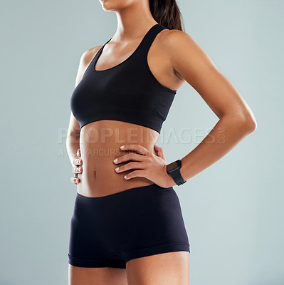 Buy stock photo Studio shot of an unrecognizable sporty woman posing with her hands on her hips against a grey background
