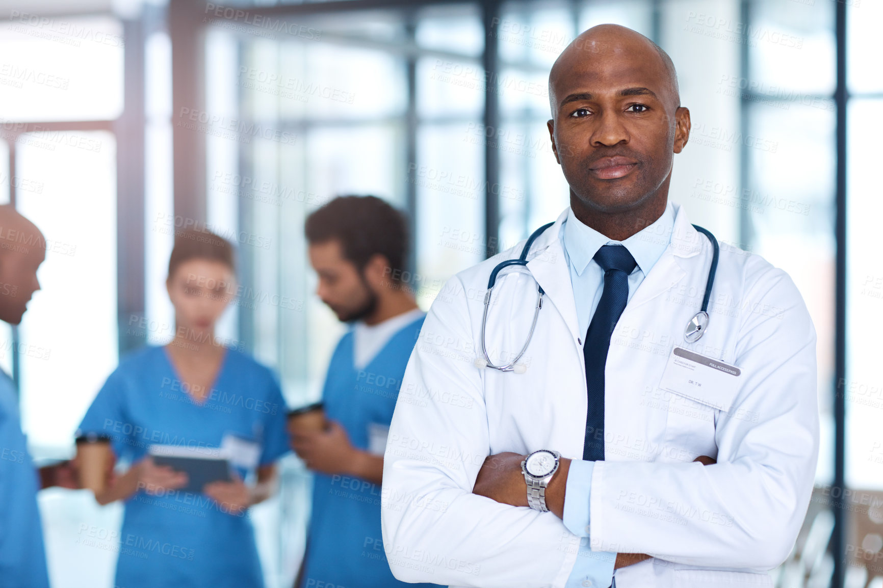 Buy stock photo Arms crossed, healthcare or portrait of doctor in hospital with team for leadership you can trust. Confident, medical and proud with serious medicine professional man in clinic for cardiology