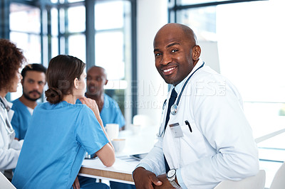 Buy stock photo Portrait of a mature doctor having a meeting with his colleagues in a hospital boardroom